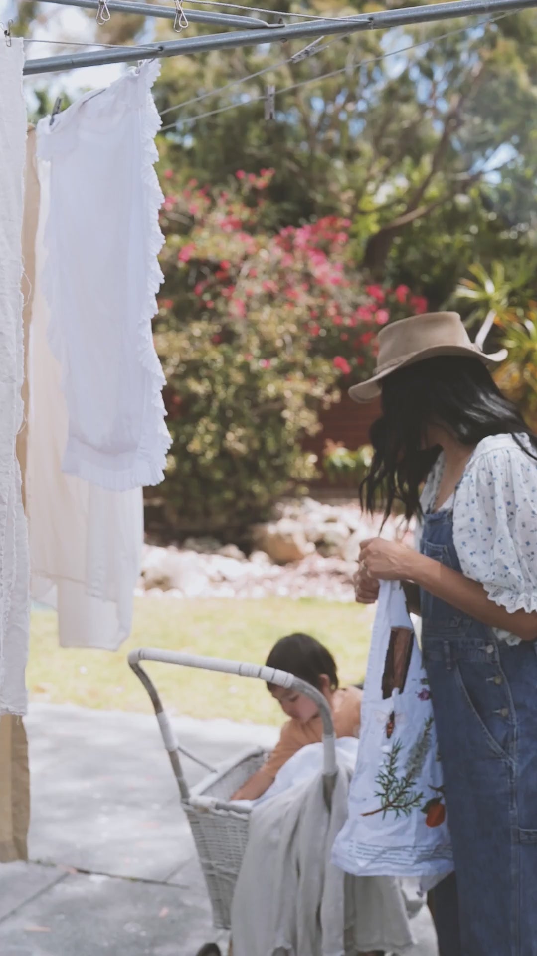 A mother and child hanging up laundry